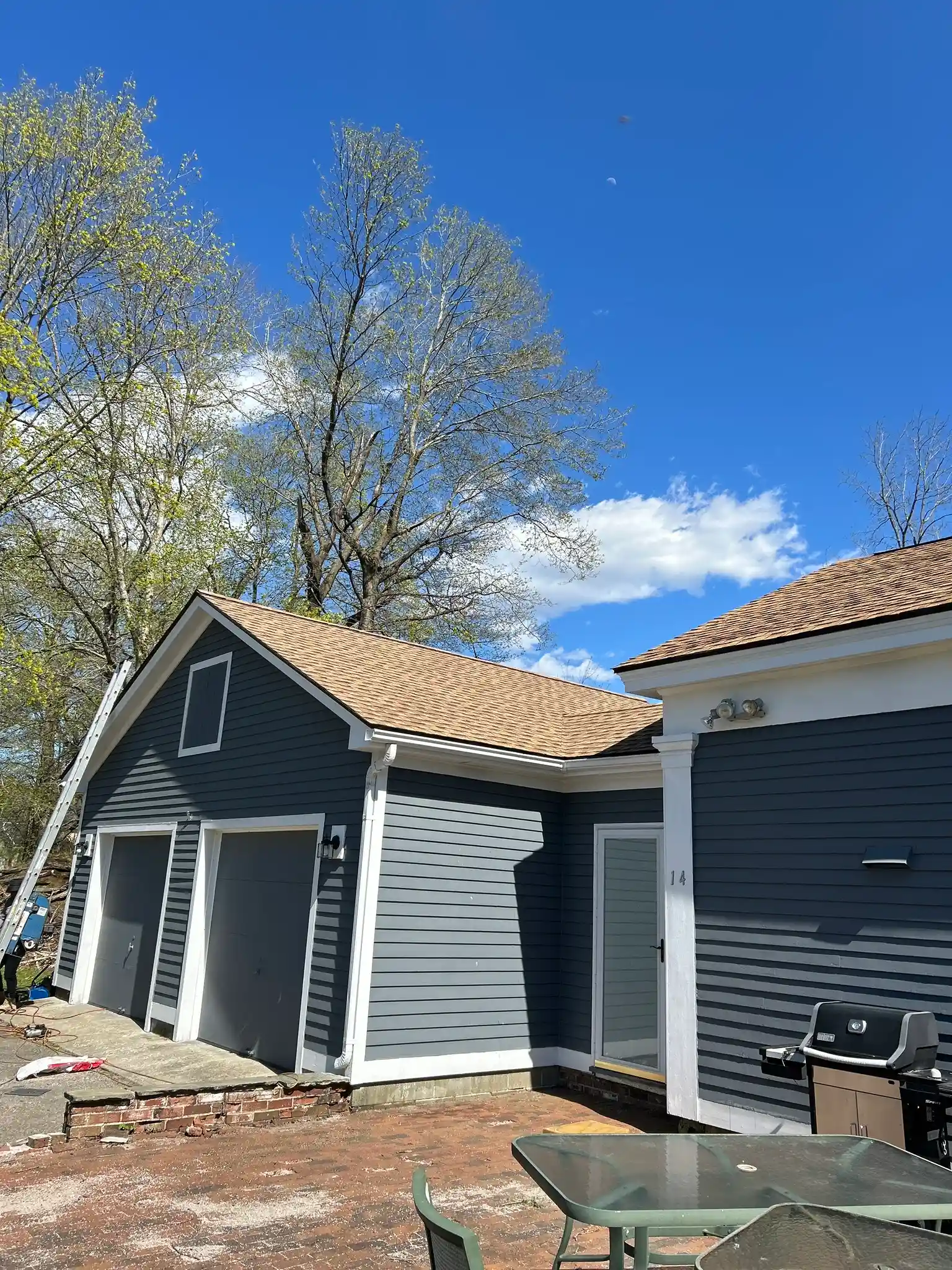 Roofing contractor replacing residential roof shingles on home in Hopkinton Rhode Island during roof replacement project