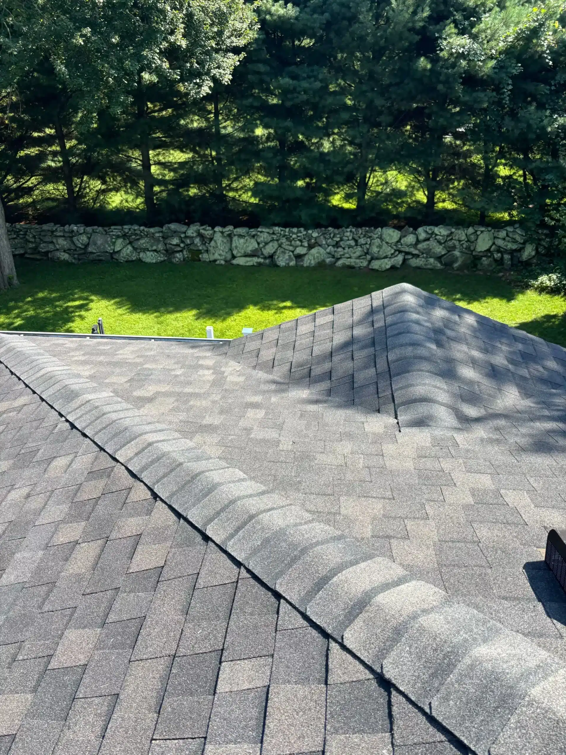 New residential roofing system with secured gutter brackets and protective gutter guards in Mystic, CT